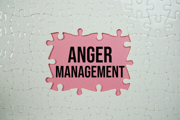 Jigsaw puzzle with a missing piece with "Anger Management" on pink background