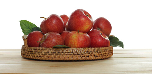 Fresh apples and green leaves on wooden table against white background