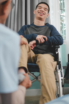 A mentally healthy young man with disability in a wheelchair being examined by doctor or physical therapist's for muscle stiffness and dyskinesia are common symptoms in people with CP(cerebral palsy).