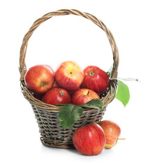 Fresh apples in wicker basket and green leaves isolated on white