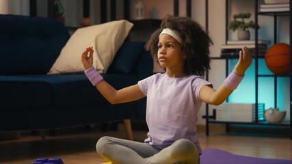 African American little girl practicing yoga pose at home, meditation exercise
