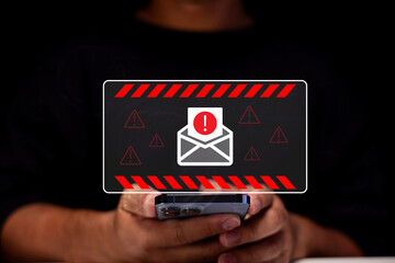 A person holding a smartphone displays a warning about a potential email threat, highlighted by...