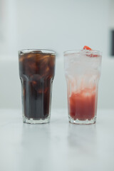 Ice americano black coffee and ice strawberry soda on white table.