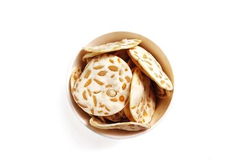 Top view of Keripik Tempe or Tempeh Chips in white bowl. Isolated on white background with copy space. Traditional Indonesian food are made from soybeans mixed with rice flour then sliced ​​thinly.