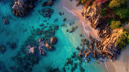 Aerial view of a coastal shoreline with clear turquoise water and rocks