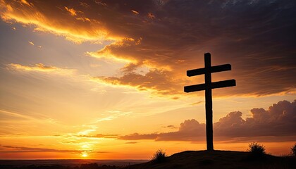 Silhouette of a double cross against a vibrant sunset sky