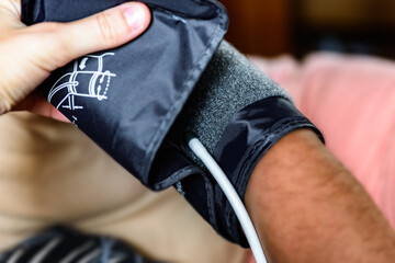 Measuring blood pressure with an automatic blood pressure monitor at home.