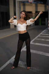 Woman posing on the road wearing fashionable clothes