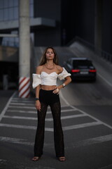 Woman posing on the road wearing fashionable clothes