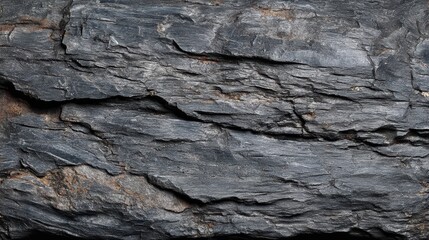 Close Up of Aged Charcoal Stained Rock Surface with Layered Fractures and Subtle Rust Tones