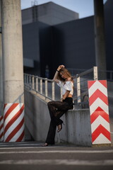 Woman posing on the road wearing fashionable clothes