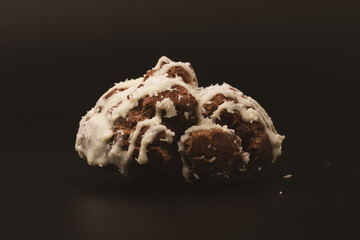 Profiteroles with coconut cream on a black background.