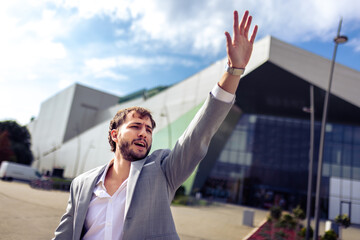 Businessman hailing taxi in front of airport building