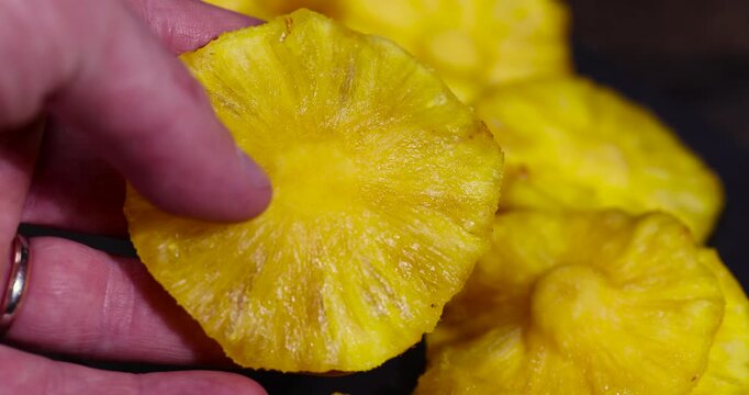 dried ripe bright yellow pineapple fruits in a hand, cut into rings and dried yellow clean slices of ripe pineapple for long-term storage and used as a sweet