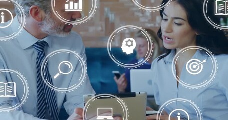 colleagues discussing technology project in cafe and initiating animated icons circling tablet - Powered by Adobe