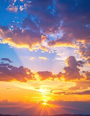 Fototapeta premium Golden sunset paints sky with vibrant orange and blue hues, sunlight bursts