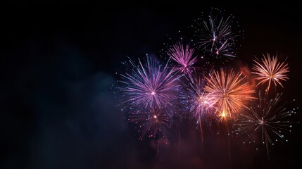 Obraz premium Fireworks display against a black night sky with colorful explosions