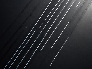 Aerial view, a dark road with bright lane lines in a minimalistic style