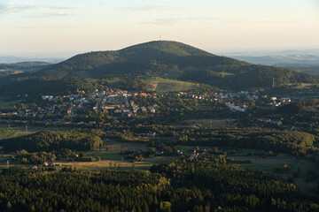 The landscape of Boguszow-Gorce with Chelmiec Mountain, seen from the observation tower on Dzikowiec Wielki. The town is surrounded by mountains and forests.