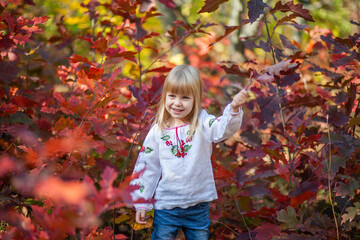 Joyful Girl Enjoying Autumn Colors, Celebrating Halloween Spirit While Playing Outdoors in October Foliage