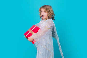 Cute child angel with gift box present. Kid wearing angel costume white dress and feather wings. Innocent child.