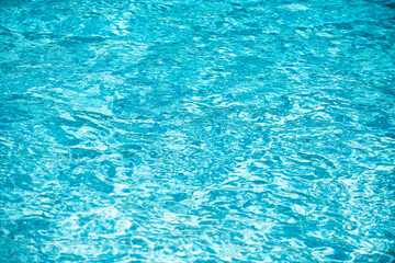 Blue pool water background. Blurred transparent clear calm water surface texture. Water waves in sunlight with copy space.