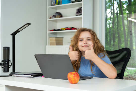 Kid using laptop for online studying at home. Child sitting at desk with laptop on virtual school lesson. Child learning with laptop. Young student . Kids watch online class on laptop. - Powered by Adobe