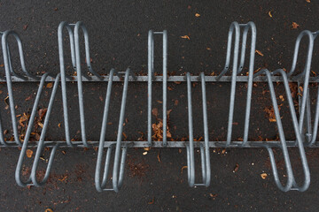 Metal bike rack in autumn with orange leaves on the ground, urban outdoor scene