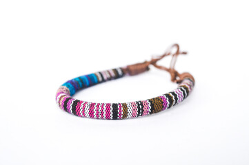 An isolated ethnic bracelet on white background. The bracelet is made off the various ropes