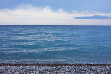 Obraz premium Beautiful view of wavy sea and pebbles on beach