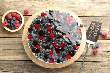 Delicious cheesecake with berries served on wooden table, flat lay