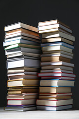 Fototapeta premium Many stacked books on table against grey background