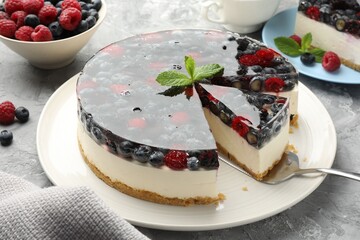 Taking piece of delicious cheesecake with berries at grey table, closeup
