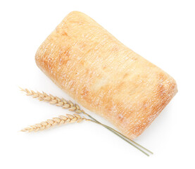 Tasty fresh ciabatta and ears of wheat isolated on white, top view