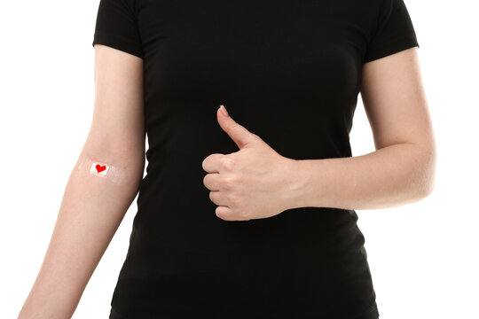 Blood donation. Woman with bandage on arm showing thumbs up against white background, closeup