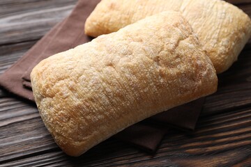 Freshly baked ciabattas on wooden table, closeup