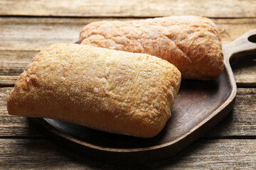 Fresh crispy ciabattas on wooden table, closeup