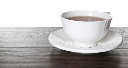 Cup of aromatic black tea on dark wooden table against white background
