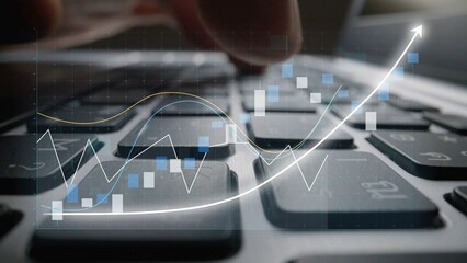 A close-up view of a hand working on a laptop keyboard with a financial graph overlay illustrating data analysis and stock market trends in a digital workspace. Copula