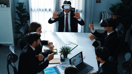 Top view of manager working on laptop and sending data analysis to business people by using VR glass headset while diverse team planning marketing strategy and looking at financial graph. Directorate.