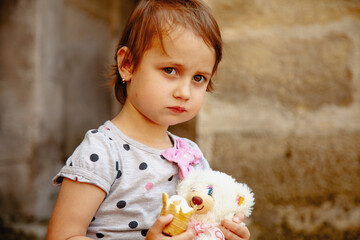 Beautiful little girl with ice cream. Sweet summer moment with ice cream and a plush companion.