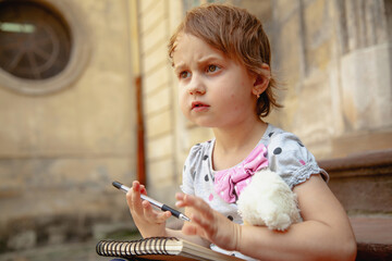 Cute child expressing creativity with pen and paper.