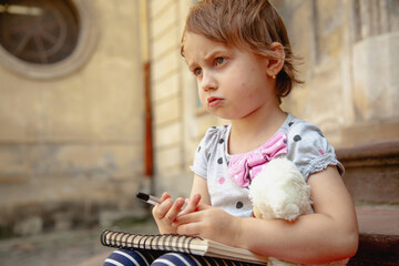 Girl holding a pen and concentrating on her artwork.