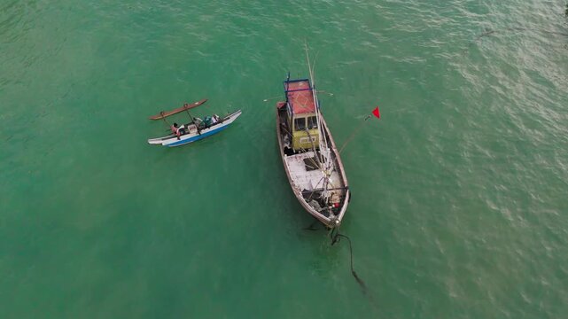 Cinematic Aerial Orbit of Fishing Boat Floating on Cyan Sea 