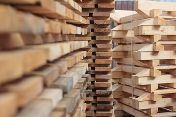 Fototapeta premium Boards are stacked. Texture of wood is out of focus. Lumber warehouse. Pallets for building materials. Selective focus.
