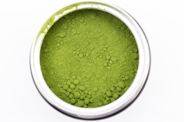 Detalle cenital de una lata metálica con té matcha en polvo