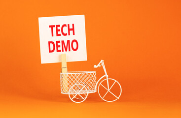 Tech demo symbol. Concept word Tech demo on beautiful white paper. Beautiful wooden clothespin. Miniature white bicycle. Beautiful orange background. Business tech demo concept. Copy space.