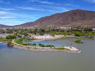 Fototapeta premium Elevated aerial shot of Jocotepec Pier along Lake Chapala with mountains in the background in Jalisco Mexico