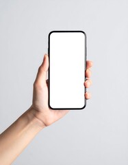 Hand holding a smartphone with a blank screen against a light gray background