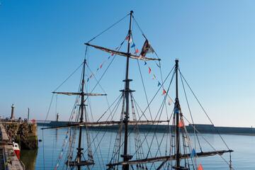 Historic ship docked at the harbor with colorful flags